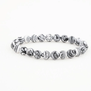 Detailed close-up of 8mm black and white marble stone beads on an elastic bracelet
