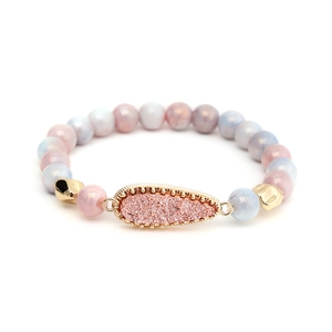 Detailansicht eines Glasperlenarmbands mit tropfenförmigem Anhänger in Pastellfarben