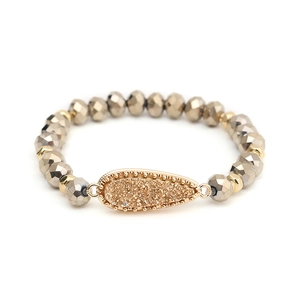 Detailed view of luxury beaded bracelet with faceted gold beads and teardrop druzy pendant