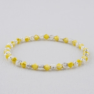 Gros plan d'un bracelet bohème en cristal jaune avec des perles de marguerite argent