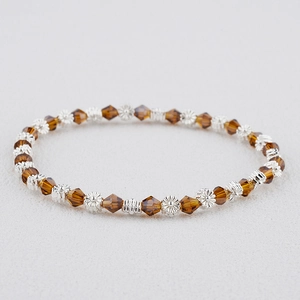Vue détaillée du bracelet bohème avec perles de cristal ambré et breloques de fleurs