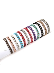 Makroansicht geometrischer Perlenarmbänder in elf Farben mit goldenen Metallakzenten im Set