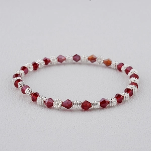 Détail des perles en cristal rouge facetté et des perles de séparation en forme de fleur