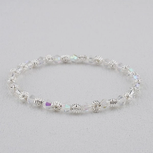 Détail des perles en cristal bohème et breloques fleurs argentées sur un bracelet perlé