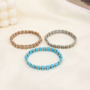 Nahaufnahme des böhmischen Perlenarmband-Sets in Senf, Grau und Blau auf Leinenstoff