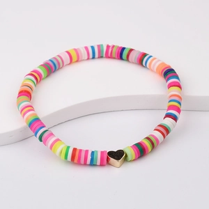Close-up of bohemian colorful heishi beads bracelet with a gold heart charm