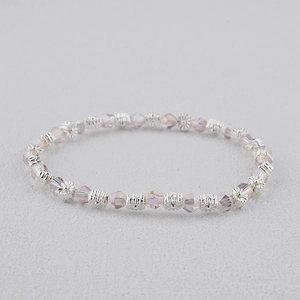 Détail macro du bracelet bohème avec perles en cristal lavande et intercalaires fleurs argentées
