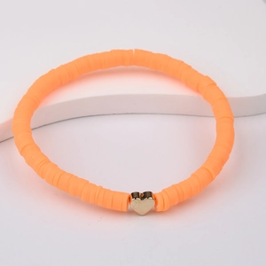 Macro detail of Bohemian bright orange polymer clay bead bracelet with gold heart accent