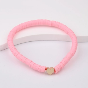 Detailed view of pink Heishi clay beads bracelet with a golden heart charm on white stand