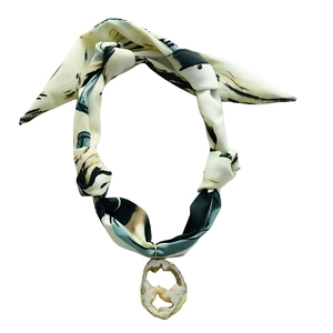 Detail of silk scarf necklace with gold-edged crystal pendant and abstract ink texture