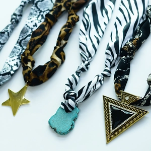 Chic scarf necklaces featuring animal prints and geometric metal pendants on white background