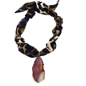 Detail of leopard print fabric choker with irregular reddish-brown agate pendant