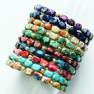 Macro shot of colorful imperial stone beaded bracelets with golden spacer accents
