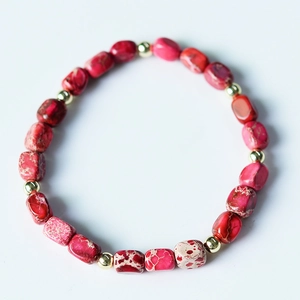 Macro shot of irregular red imperial stone beads with polished gold metal spacer beads