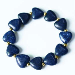 Gros plan de perles de lapis-lazuli en forme de cœur avec intercalaires dorés sur bracelet