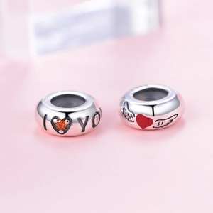 Macro detail of S925 silver charm with I Love You engraving and red heart wing design