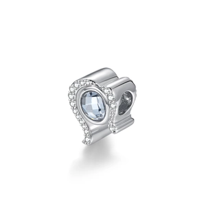 Detalle macro del dije corazón en plata S925 con gema azul claro e incrustación de circonita