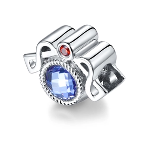 Vista macro de abalorio de plata S925 con gema azul tallada y detalle de rubí