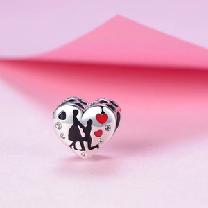 Dettaglio macro dello charm a cuore in argento S925 con scena di proposta e pietre in zirconia