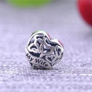 Vista macro di charm a cuore in argento S925 con incisione My Wife su nastro