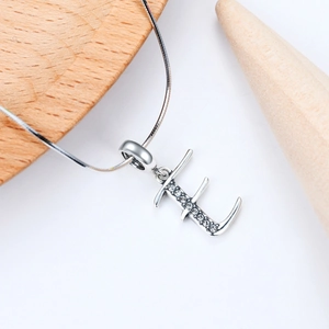 Macro d'un pendentif lettre E en argent avec oxydes de zirconium et chaîne