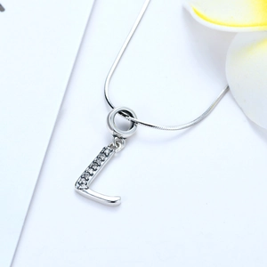 Vue macro du pendentif lettre L en argent 925 avec zircons sur une chaîne en serpent