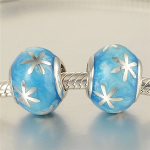 Makroaufnahme von blauen Schneeflocken-Glasanhängern auf einem Schlangenarmband