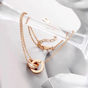 Collana in oro rosa con doppio anello, numeri romani e pavé di zirconi luccicanti