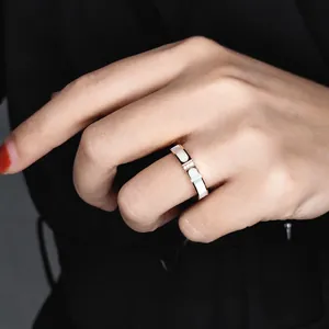 Details eines 18K Roségold-Edelstahlrings mit weißer Muscheleinlage und drei kleinen Steinen