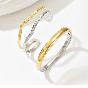 Detalle de brazaletes bicolor oro y plata con textura irregular y diseño minimalista