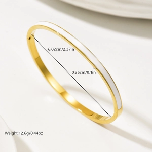 Detail view of gold-plated bangle with white enamel inlay and side clasp mechanism