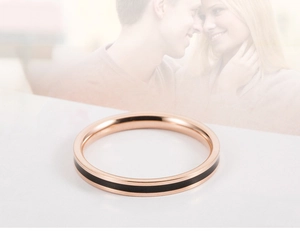 Detail van roségouden titanium stalen ring met zwart emaille inleg voor koppels