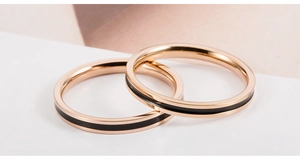 Macro-opname van rosé goud titanium stalen ringen met zwarte emaille strepen