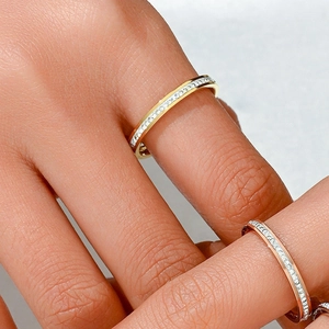 Anelli chic in acciaio al titanio con pavé in oro e oro rosa sulla mano di modella