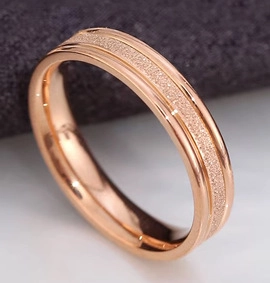 Close-up of rose gold stainless steel ring with frosted sandblast finish and polished edges