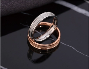Detailed view of silver and rose gold stainless steel rings with sandblasted finish