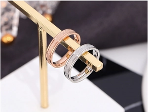 Macro detail of sandblasted rose gold and silver titanium steel rings on a gold display