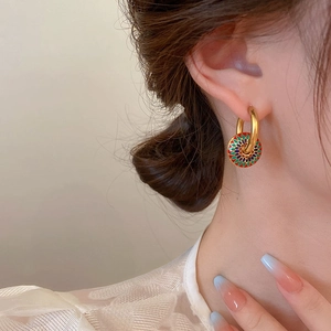 Orecchini a cerchio vintage dorati con ciondoli in smalto colorato indossati da modella