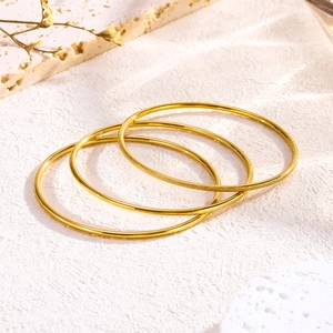 Set of four gold stainless steel bangles featuring three polished and one matte finish ring