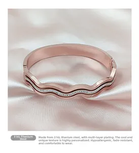 Detail of rose gold 316L titanium steel wave bracelet with zircon inlay on pink silk