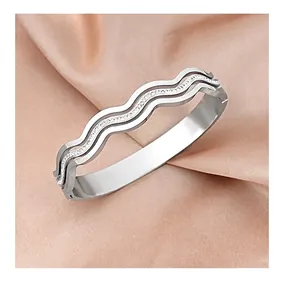 Detail of silver wavy bangle with micro-pave zircons on champagne silk background