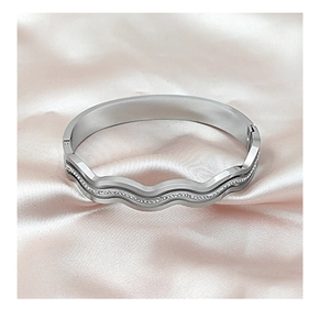 Detail of a wavy silver titanium steel bangle with sparkling zircon stones inlay