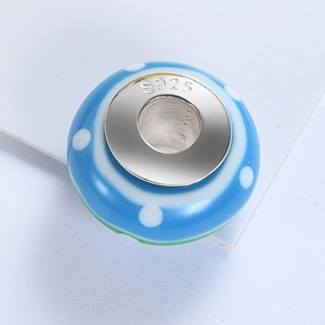 Close-up of S925 sterling silver blue glass charm bead with white polka dots for bracelets