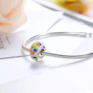 Macro-detail van een veelkleurige glaskraal op een gepolijste zilveren slangenketting