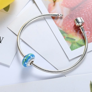 S925 sterling silver bracelet with a blue glass bead featuring green stripes and dots