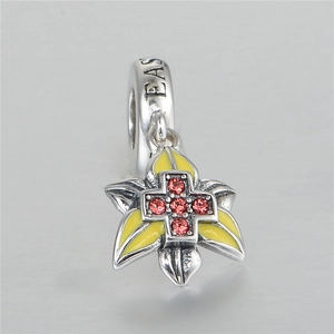 Detalle macro del charm flor de Pascua en plata S925 con esmalte amarillo y cristales rojos
