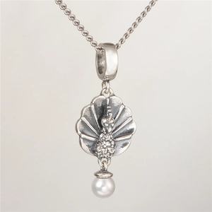 Macro detail of S925 silver peacock pendant with cubic zirconia and a white pearl drop