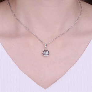 Detail of silver architectural charm with red gemstone on a delicate chain necklace