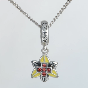 Detalle del dije de flor de Pascua en plata S925 con cruz de circón rojo y grabado