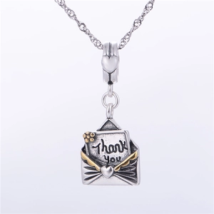 Détail macro du pendentif enveloppe en argent S925 avec gravure et cœur doré